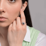 Kobieta z pierścionkiem z niebieskim topazem i brylantami na palcu, stylowa biżuteria od Venetia Jewels