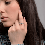 Stylowy pierścionek z niebieskim topazem i brylantami noszony na dłoni modelki