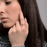 Stylowy pierścionek z niebieskim topazem i brylantami noszony na dłoni modelki