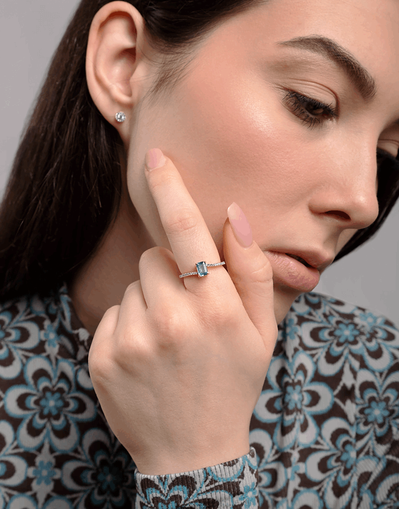 Pierścionek z topazem i brylantami na dłoni modelki w eleganckiej stylizacji