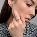 Pierścionek z topazem i brylantami na dłoni modelki w eleganckiej stylizacji