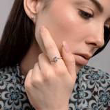 Pierścionek z topazem i brylantami na dłoni modelki w eleganckiej stylizacji