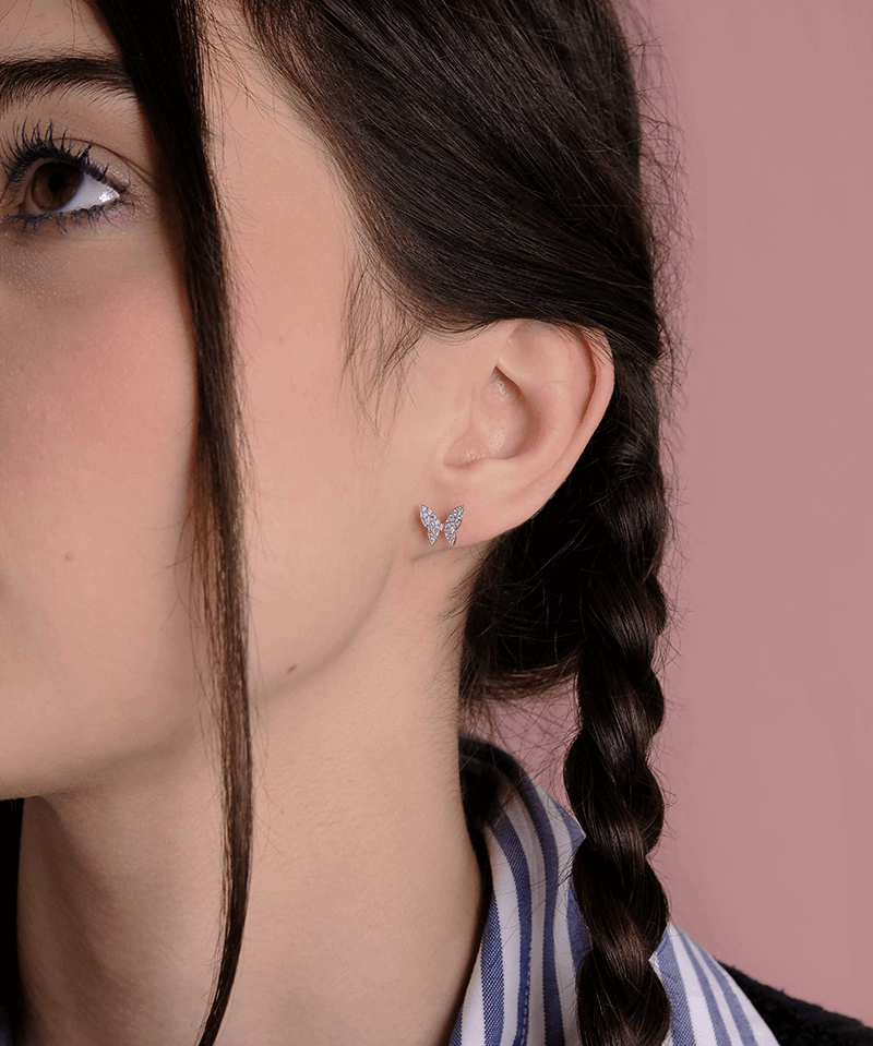 Kolczyki motyle z brylantami na uchu modelki, subtelny i elegancki design od Venetia Jewels