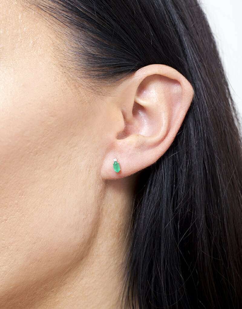 Kolczyki szmaragdowe brylantowe w stylu minimalistycznym noszone na uchu