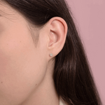 Kolczyki sztyfty z brylantami na uchu, idealne do codziennych stylizacji.