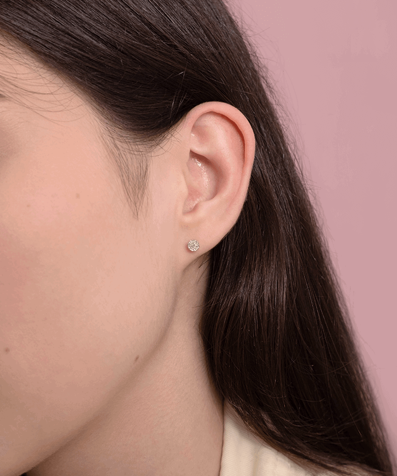 Kolczyki sztyfty z brylantami na uchu, idealne do codziennych stylizacji.