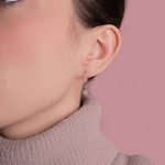 Eleganckie kolczyki z brylantami od Venetia Jewels na delikatnej modelce w swetrze