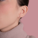 Eleganckie kolczyki z brylantami od Venetia Jewels na delikatnej modelce w swetrze