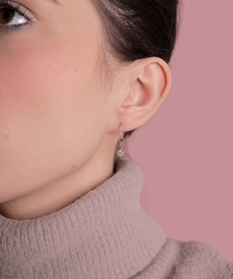 Eleganckie kolczyki z brylantami od Venetia Jewels na delikatnej modelce w swetrze