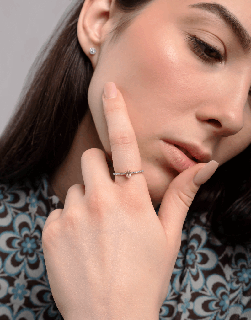 Elegancki pierścionek z morganitem i brylantami na dłoni modelki w stylowej bluzce