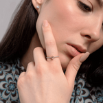 Elegancki pierścionek z morganitem i brylantami na dłoni modelki w stylowej bluzce