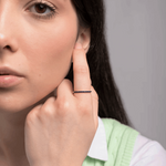 Pierścionek z niebieskim szafirem noszony przez kobietę z delikatnym uśmiechem