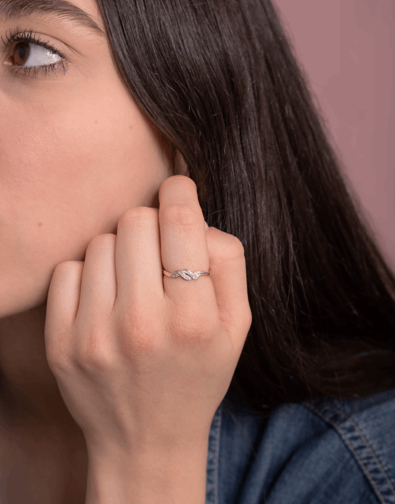 Spleciony pierścionek z brylantami noszony przez kobietę, idealny na wyjątkowe okazje