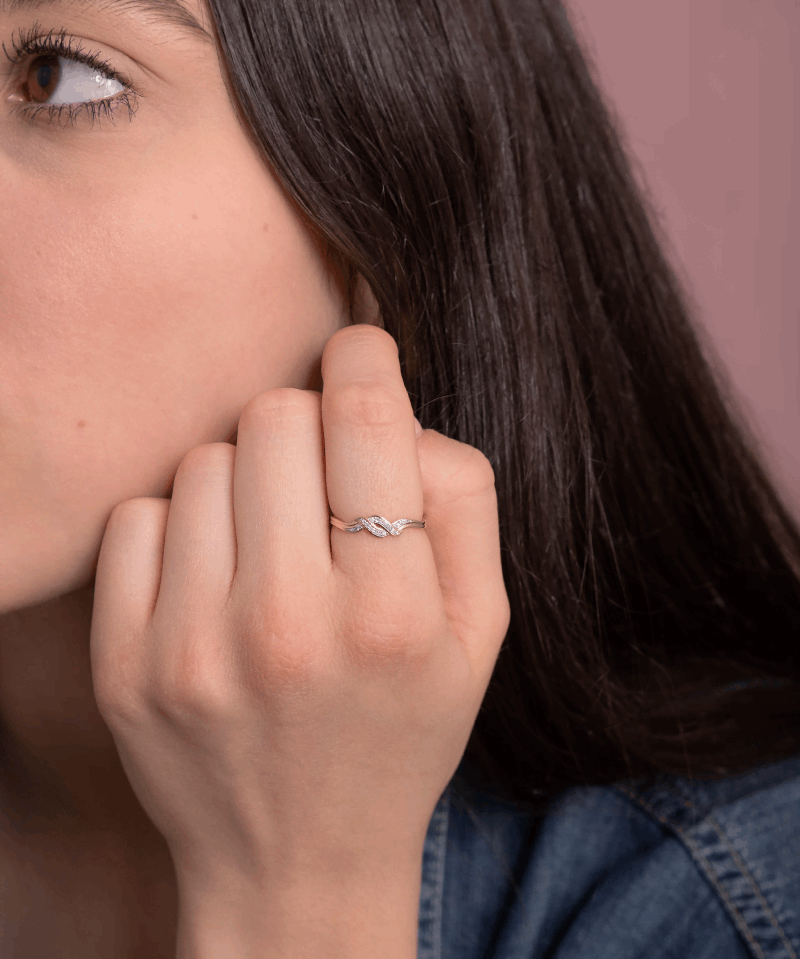 Spleciony pierścionek z brylantami noszony przez kobietę, idealny na wyjątkowe okazje