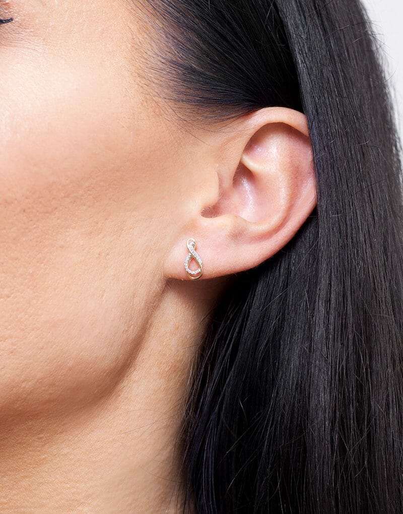 Eleganckie szafirowe kolczyki sztyfty vintage z delikatnym wzorem na uchu modelki