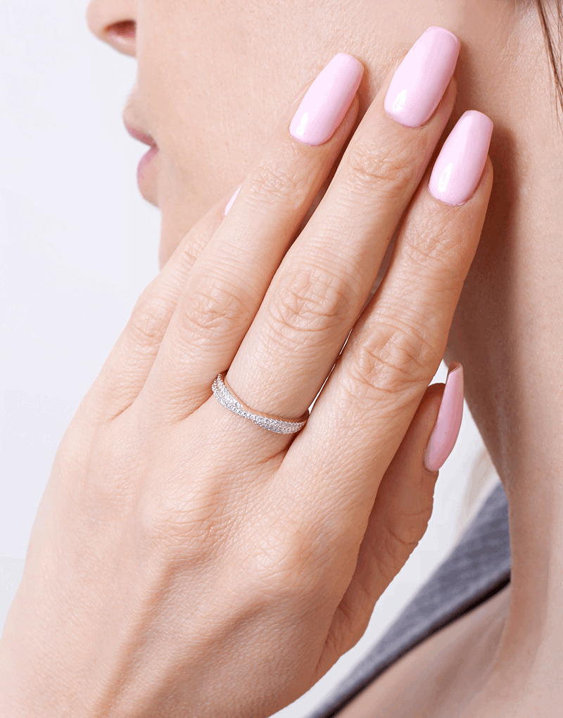 Złoty pierścionek z brylantami na delikatnym palcu kobiety z różowym manicure od Venetia Jewels