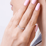 Złoty pierścionek z brylantami na delikatnym palcu kobiety z różowym manicure od Venetia Jewels