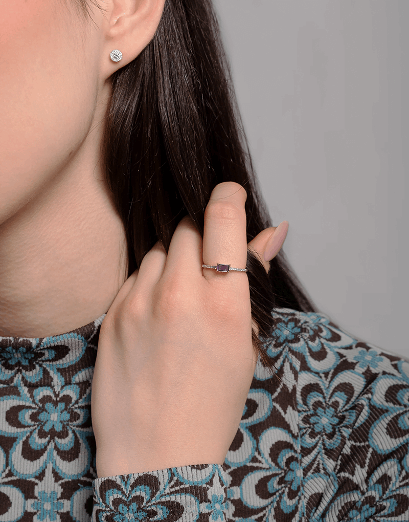 Pierścionek vintage z tanzanitem i brylantami na dłoni modelki, z eleganckim wzorem na bluzce