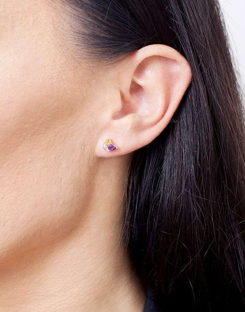 Wielokolorowe kolczyki sztyfty od Venetia Jewels na uchu modelki, idealne do codziennych stylizacji