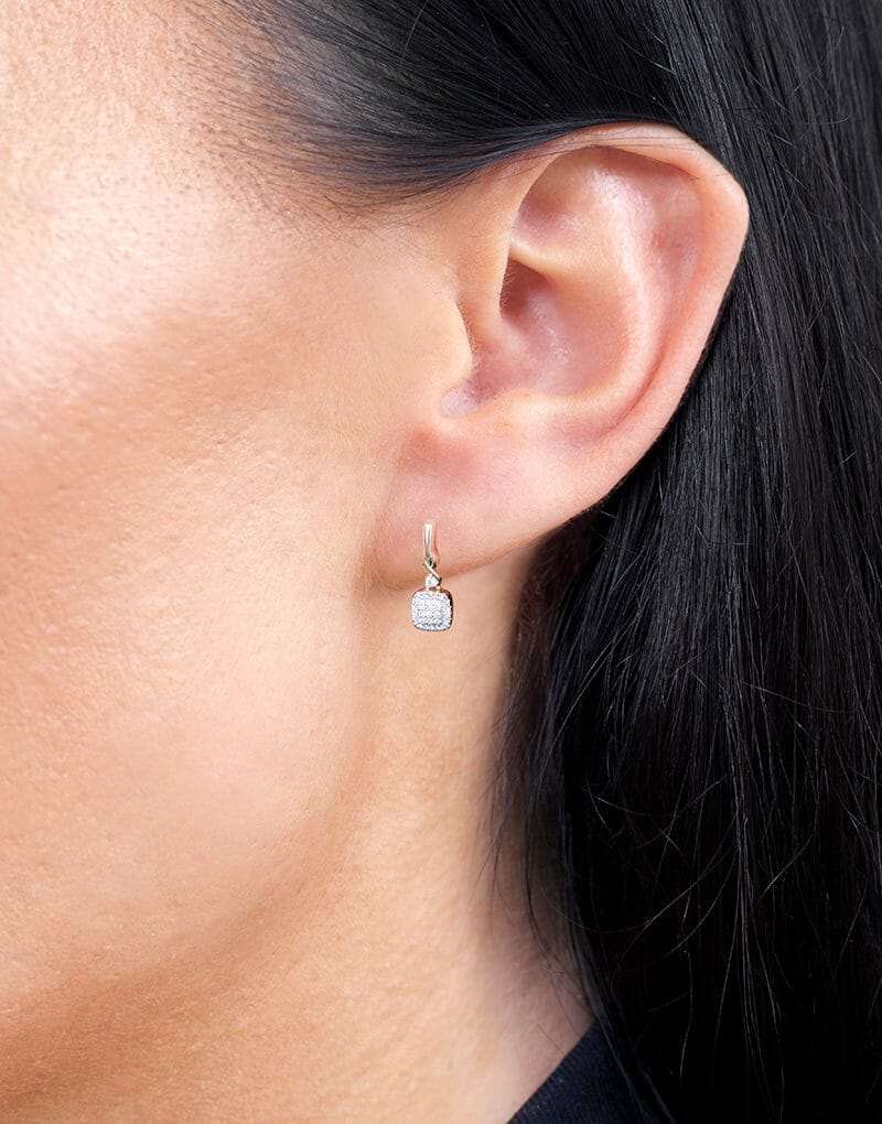 Eleganckie kwadratowe złote kolczyki z brylantami noszone na uchu, idealne na specjalne okazje