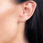 Eleganckie kwadratowe złote kolczyki z brylantami noszone na uchu, idealne na specjalne okazje