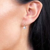 Eleganckie kwadratowe złote kolczyki z brylantami noszone na uchu, idealne na specjalne okazje