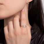 Złoty pierścionek z brylantami w kształcie spirali noszony przez osobę z długimi włosami