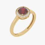 Złoty pierścionek z rubinem otoczony drobnymi diamentami, elegancki i stylowy.