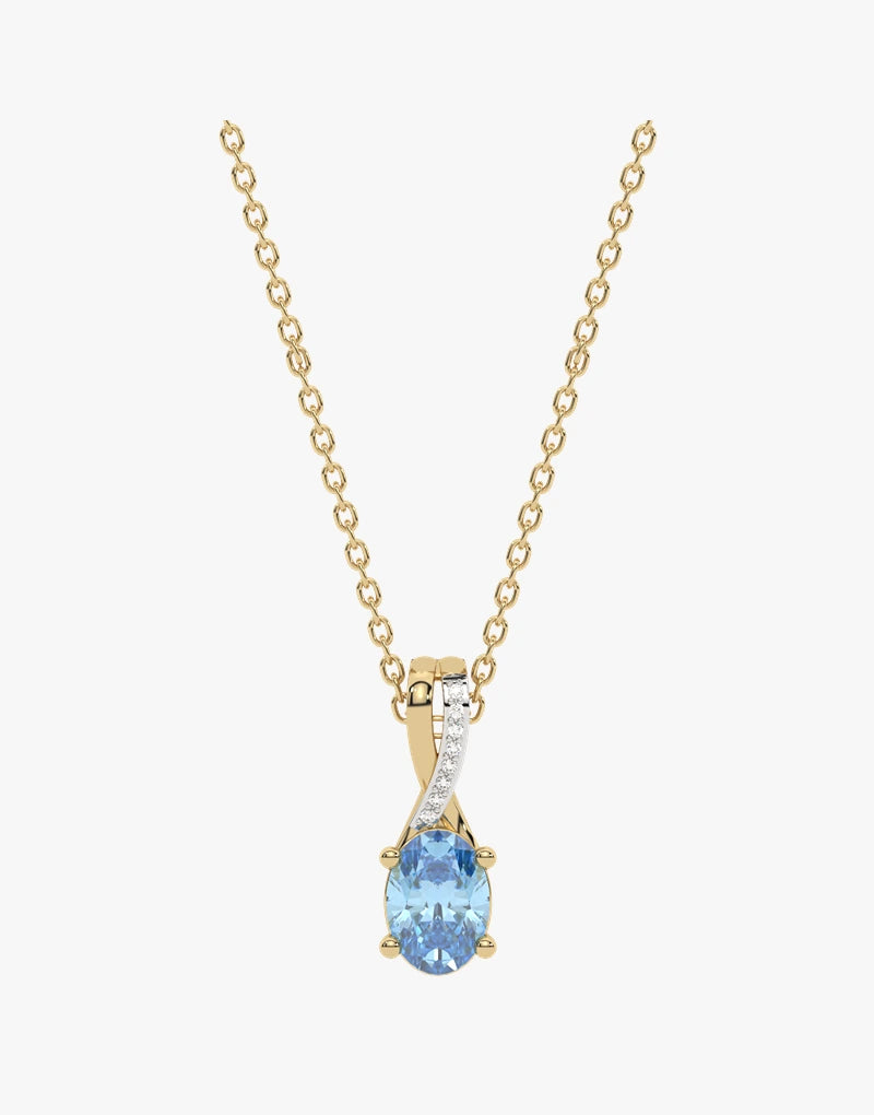 Złoty wisiorek z niebieskim topazem, ozdobiony diamentami na delikatnym łańcuszku.