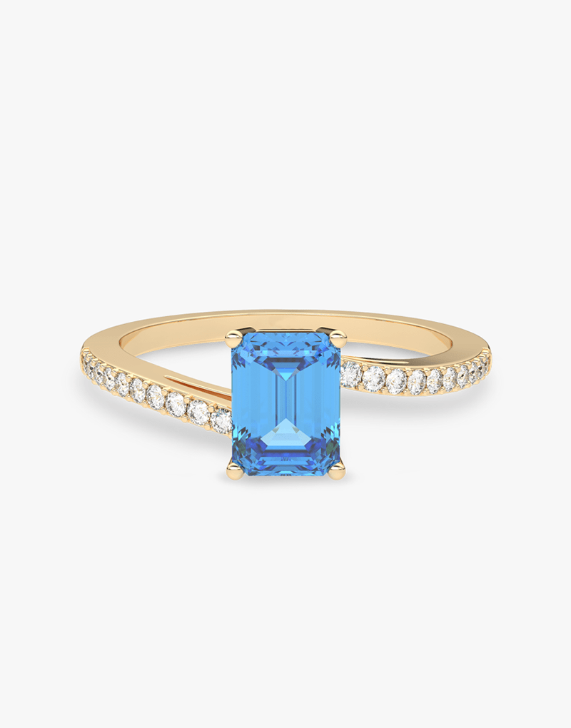 Złoty pierścionek z topazem i brylantami z niebieskim kamieniem w centralnej części