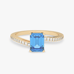 Złoty pierścionek z topazem i brylantami z niebieskim kamieniem w centralnej części