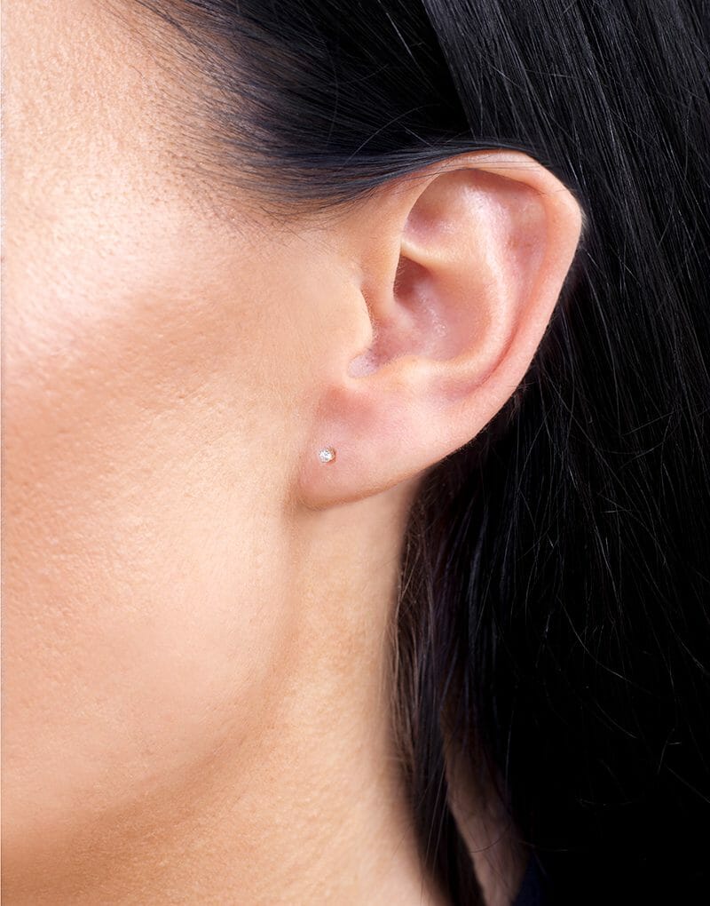 Brylantowe kolczyki sztyfty od Venetia Jewels na uchu modelki w zbliżeniu