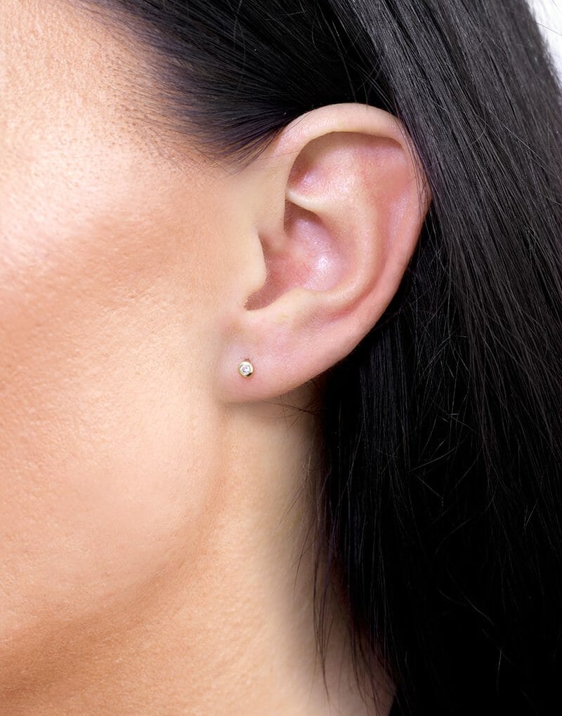 Brylantowe kolczyki sztyfty Venetia Jewels na uchu, minimalistyczny i elegancki design
