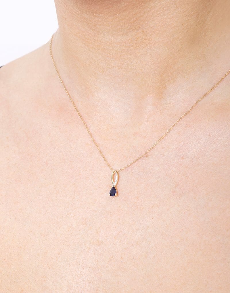 Złota zawieszka z szafirem na delikatnym łańcuszku, idealna na eleganckie okazje