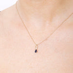 Złota zawieszka z szafirem na delikatnym łańcuszku, idealna na eleganckie okazje