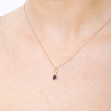 Złota zawieszka z szafirem na delikatnym łańcuszku, idealna na eleganckie okazje