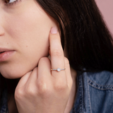 Złoty pierścionek z brylantami noszony na palcu, w stylowej scenerii