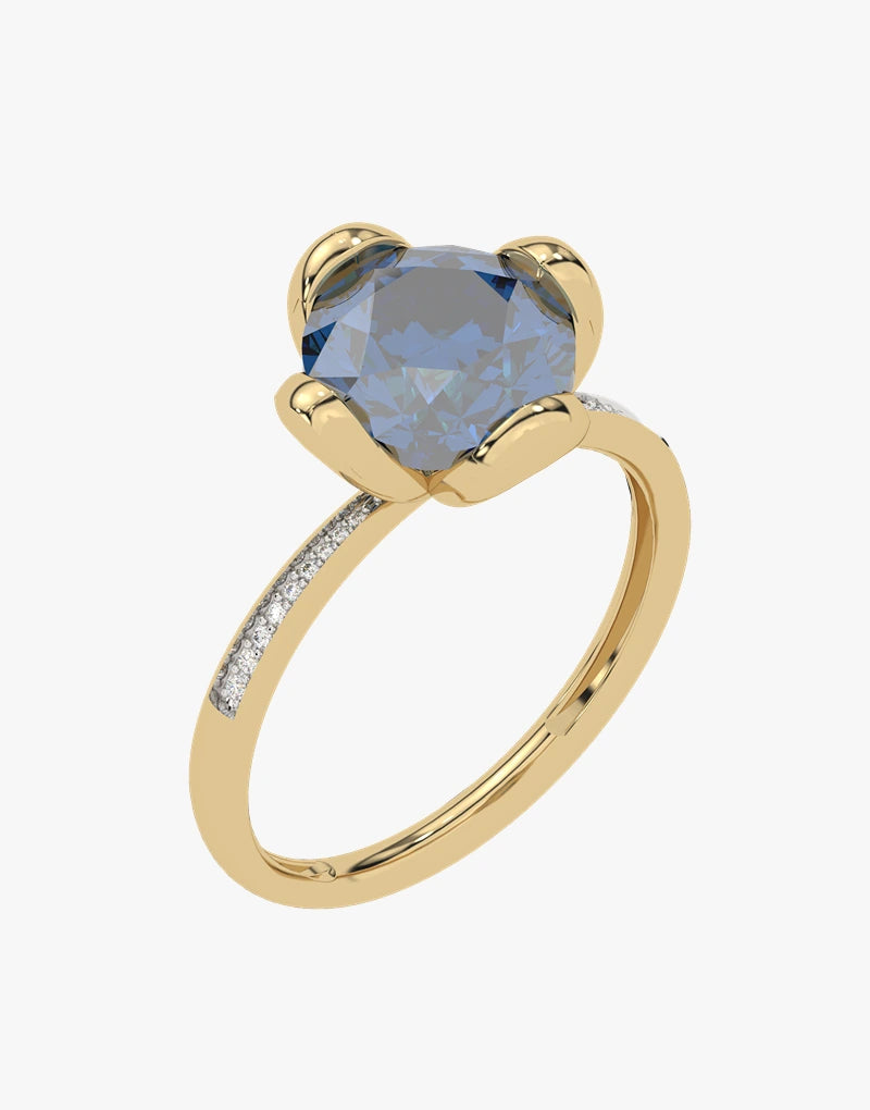 Złoty pierścionek z London Blue Topaz - Niebieski Blask od Venetia Jewels ma duży, okrągły topaz London Blue, przytrzymywany przez cztery zęby. Obrączka jest ozdobiona małymi błyszczącymi brylantami po obu stronach kamienia szlachetnego.