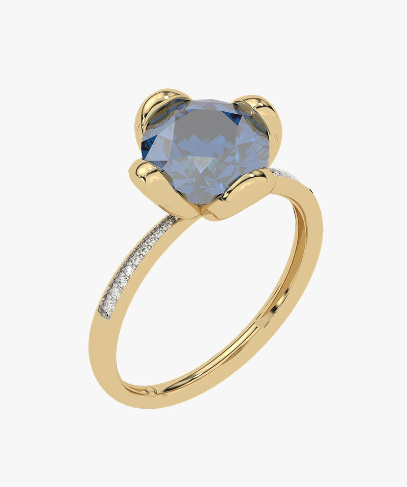 Złoty pierścionek z London Blue Topaz - Niebieski Blask od Venetia Jewels ma duży, okrągły topaz London Blue, przytrzymywany przez cztery zęby. Obrączka jest ozdobiona małymi błyszczącymi brylantami po obu stronach kamienia szlachetnego.