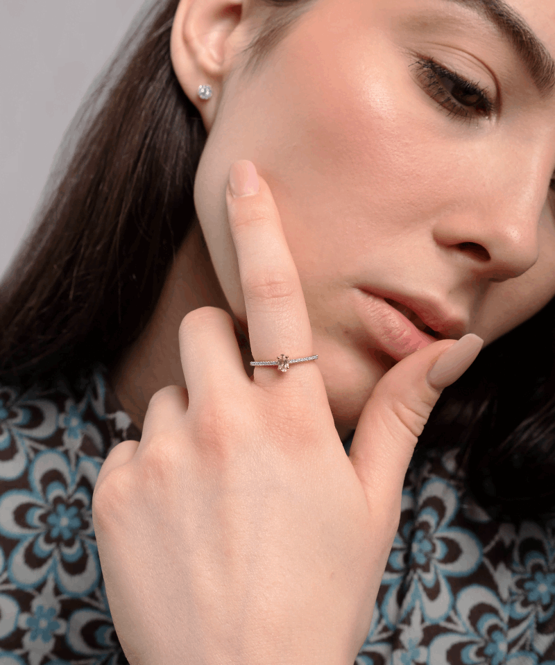 Elegancki pierścionek z morganitem i brylantami na dłoni modelki w stylowej bluzce
